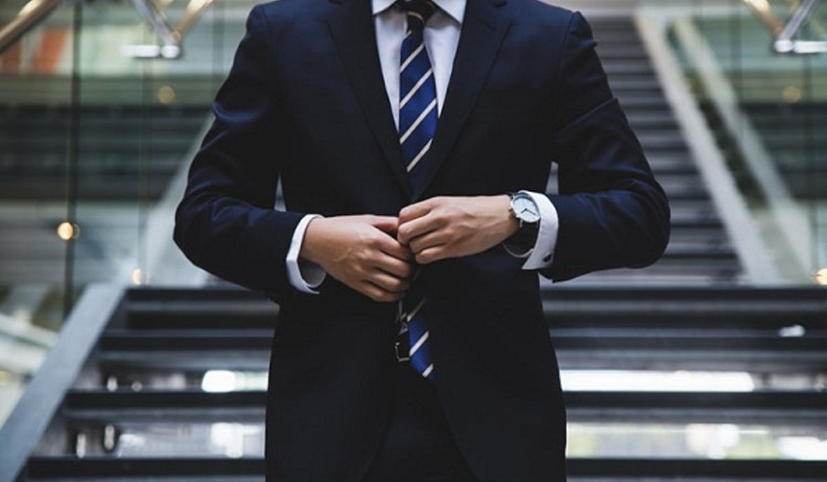 man in a suit buttoning his suit