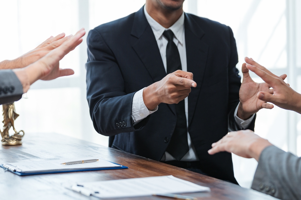 Lawyers engaged in a detailed discussion about contract terms during a meeting in a professional office setting