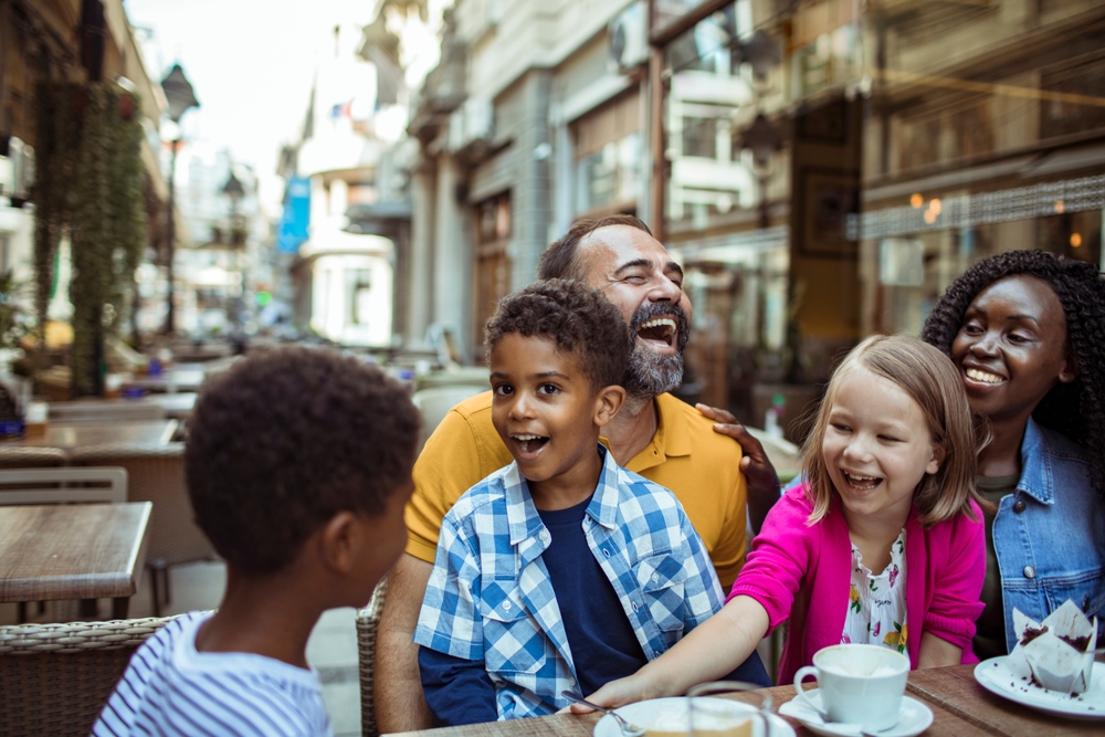 Stepfamily sharing joyful moments at an outdoor cafe in the city